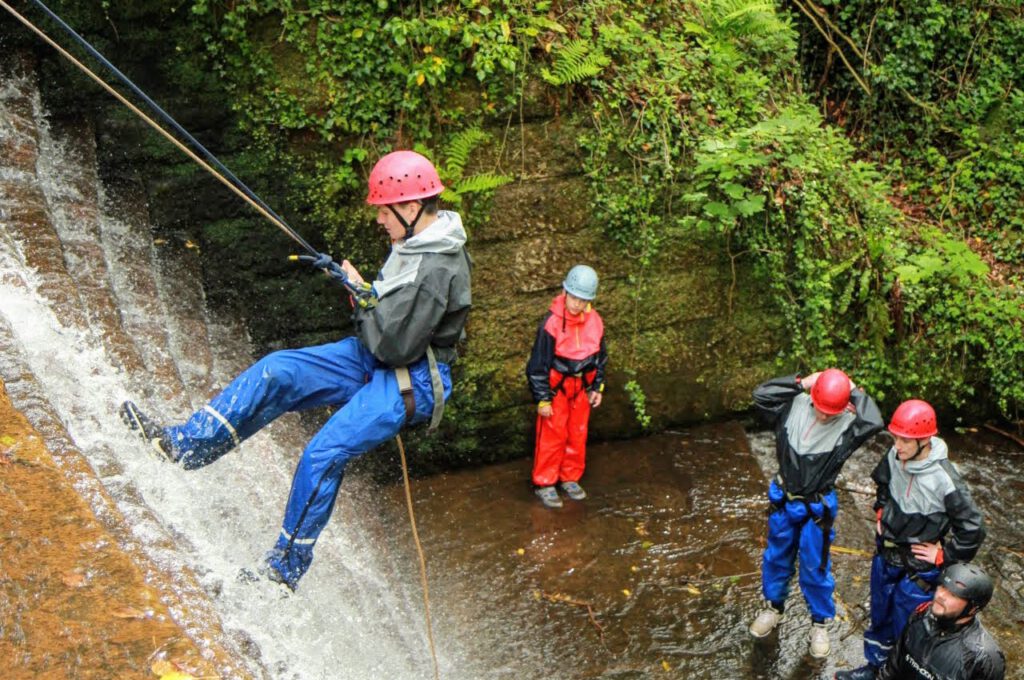 man abseiling down the old mill waterfall