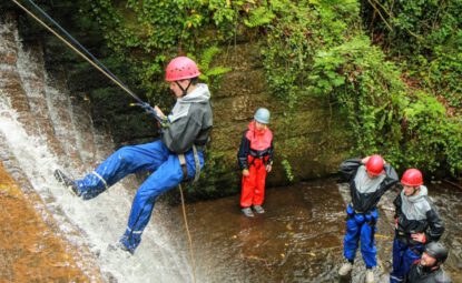 man abseiling down the old mill waterfall