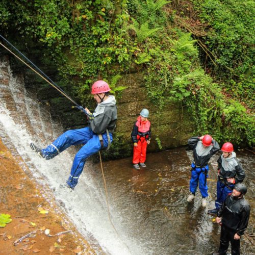 man abseiling down the old mill waterfall