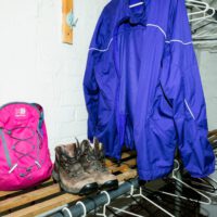 walking boots on rack and coats hanging inside drying room