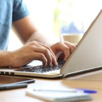 man typing on laptop