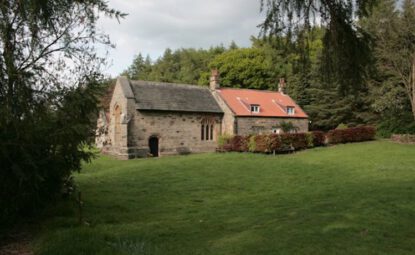 A small stone chapel on a wooded slope