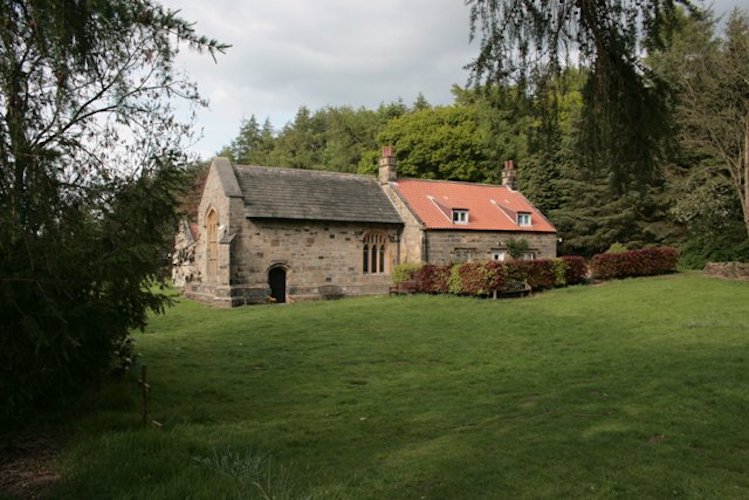 A small stone chapel on a wooded slope